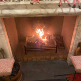 Fireplace with lit fire and Elves on the Shelf figurines on a mantel.